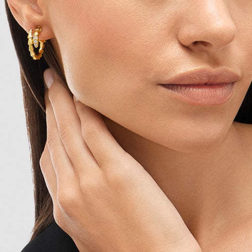 Bulgari Serpenti gold-plated hoop earrings with cubic zirconia accents, shown on a woman