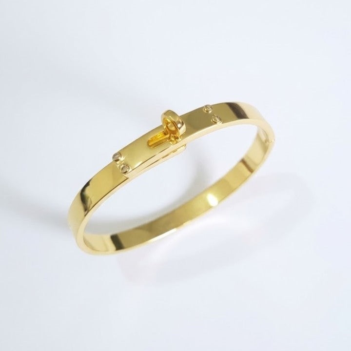 Hermes Kelly padlock bangle in gold-plated finish on white background