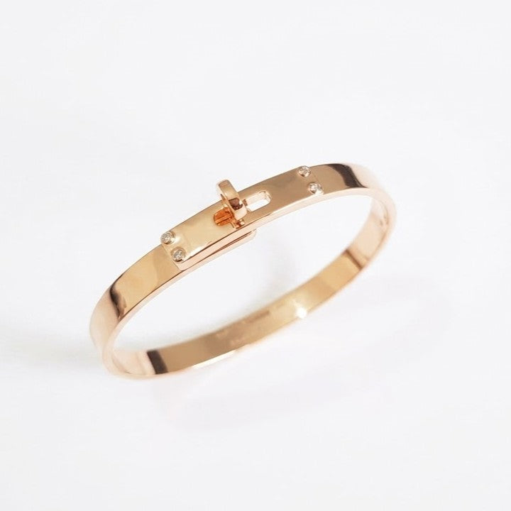 Hermes Kelly padlock bangle in Rose gold-plated finish on white background