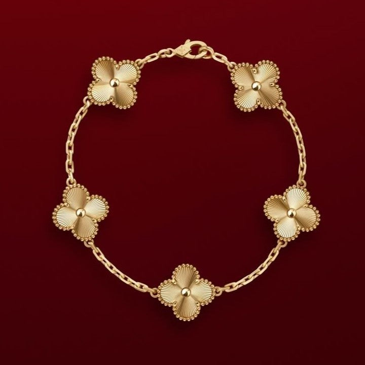 an Cleef Alhambra gold bracelet with an iconic flower motif and gold-plated finish