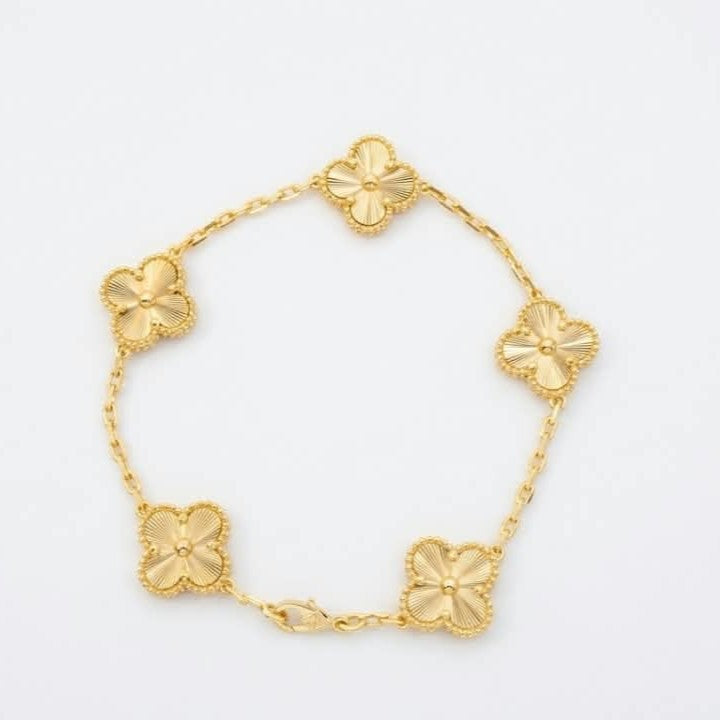 an Cleef Alhambra gold bracelet with an iconic flower motif and gold-plated finish