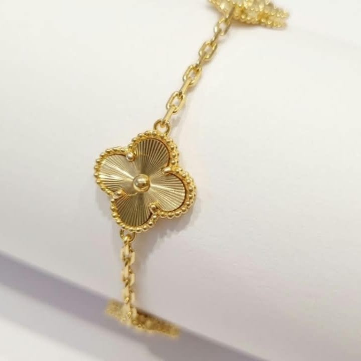 an Cleef Alhambra gold bracelet with an iconic flower motif and gold-plated finish