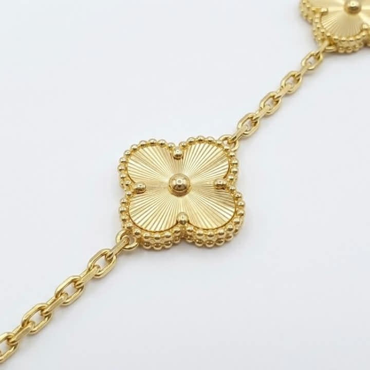 an Cleef Alhambra gold bracelet with an iconic flower motif and gold-plated finish